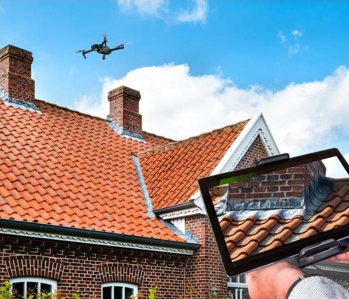 A drone flying over a house, reviewing the shingles.